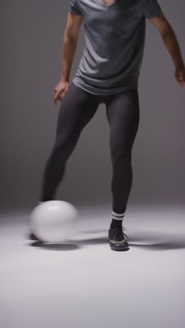 Vertical-Video-Close-Up-Studio-Shot-Of-Female-Footballer-Wearing-Sports-Clothing-Controlling-Ball-With-Feet